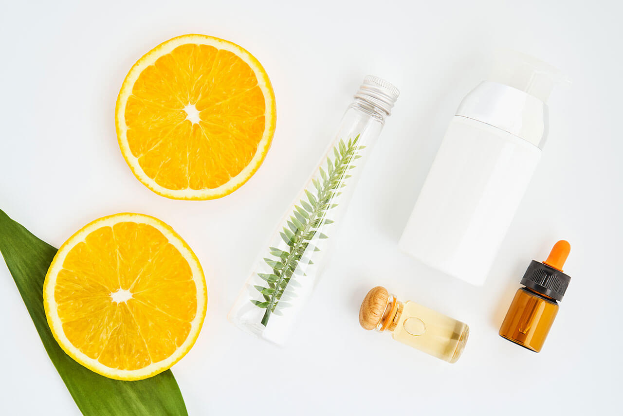 overhead shot of sliced oranges and jars of supplements that can help you reach the RDA for Vitamin C