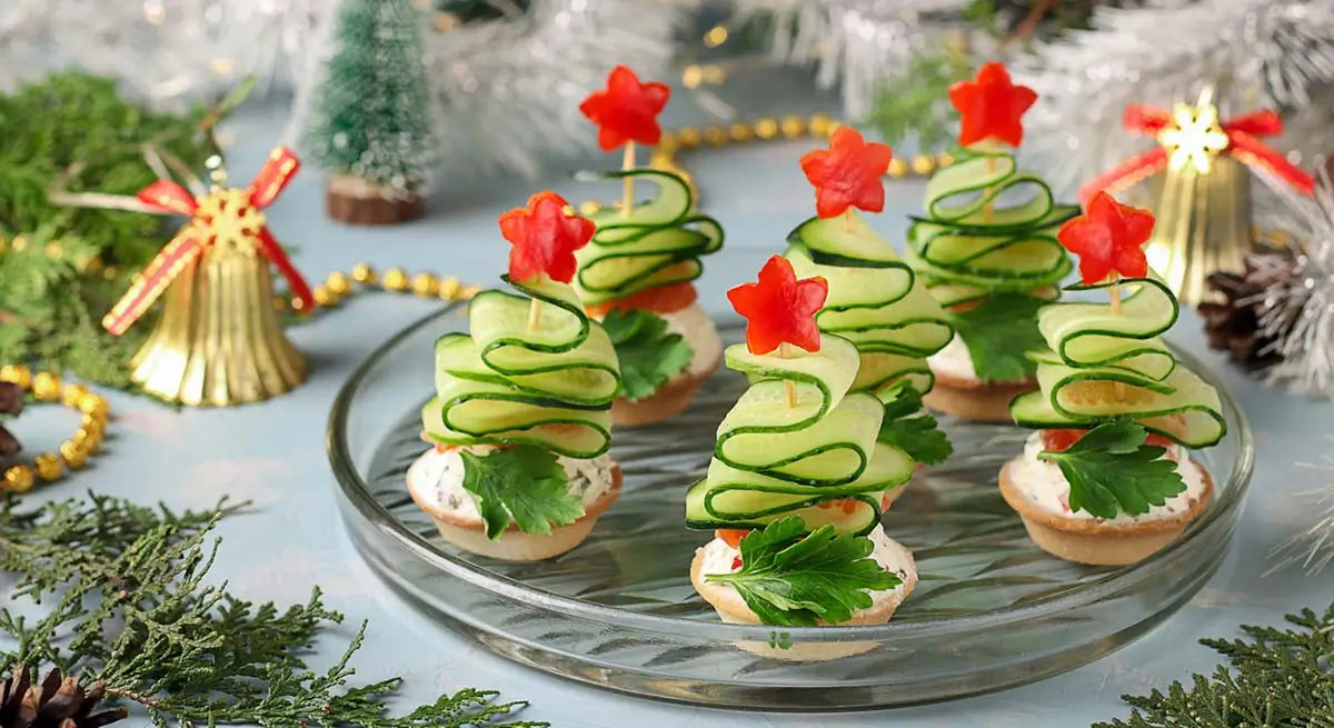 healthy christmas tree cucumber tarts on a plate with christmas decorations