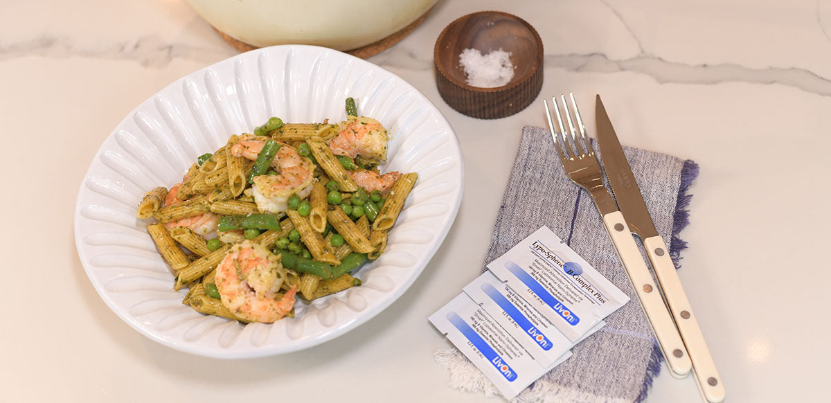 high-protein pasta with shrimp on plate with packets of lypo-spheric b complex plus on the side