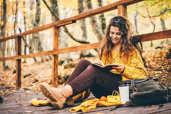 woman writing in journal on a fall day