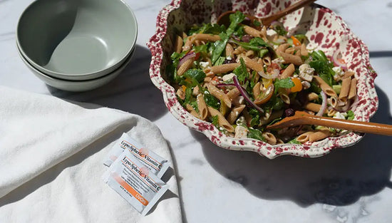 healthy pasta salad in a bowl with two packets of lypo c